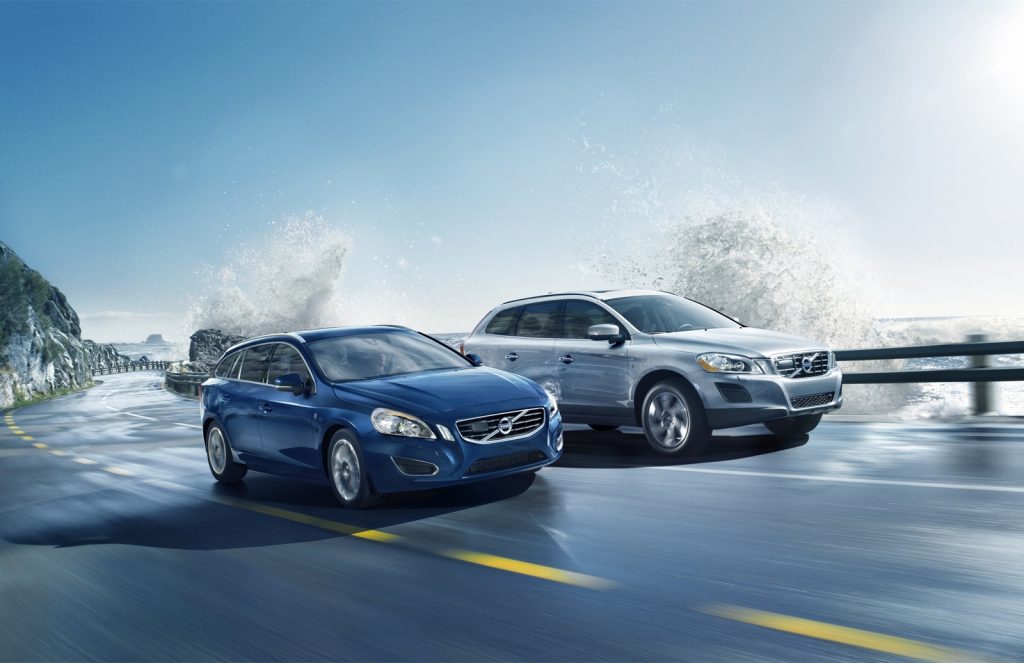 En blå volvo och en grå volvo kör tillsammans på vägen.