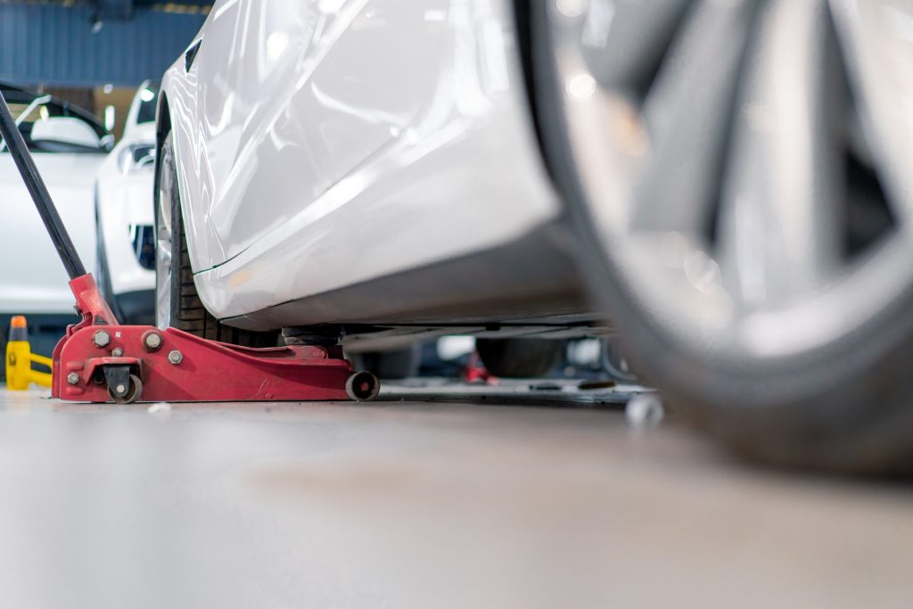 En bil lyfts upp på en däckverkstad som heter däckfixaren.