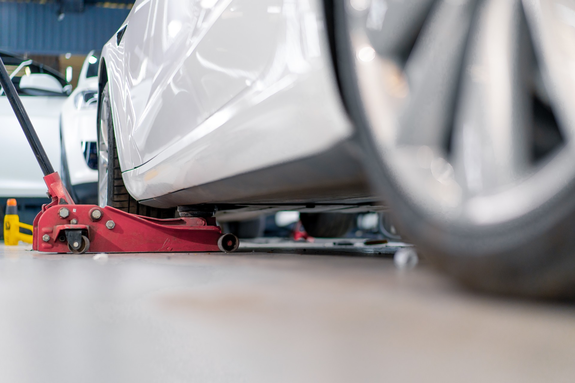 En bil lyfts upp på en däckverkstad som heter däckfixaren. 